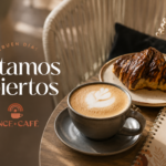 A latte and chocolate croissant sit beside Once Café branding in a cozy setting announcing, “Estamos abiertos” in Narvarte.