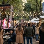 A lively Mexico City weekend market offers gourmet food stalls, live music, and cultural events beneath illuminated trees.